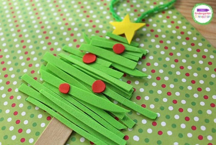 To complete the foam Christmas ornament, cut a piece of ribbon or twine, shape it into a loop, and glue it to the back of the tree for hanging.
