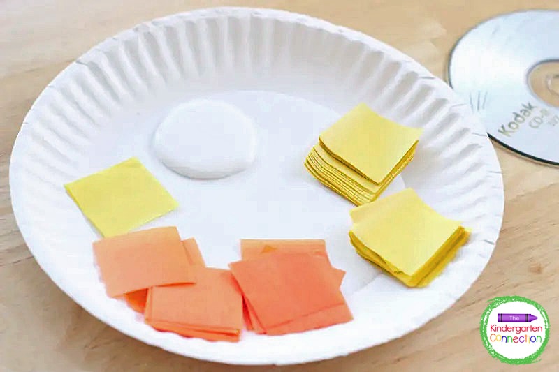 To begin, place a good amount of glue on a paper plate with some tissue paper squares.