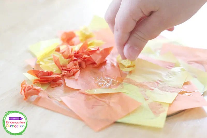 Continue to glue crumpled pieces of tissue paper to the CD leaving the edges uncovered.