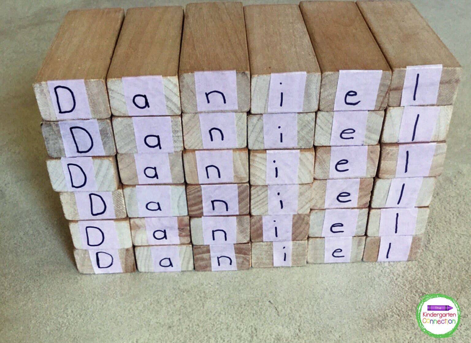Students build their names using the blocks to create fun towers.