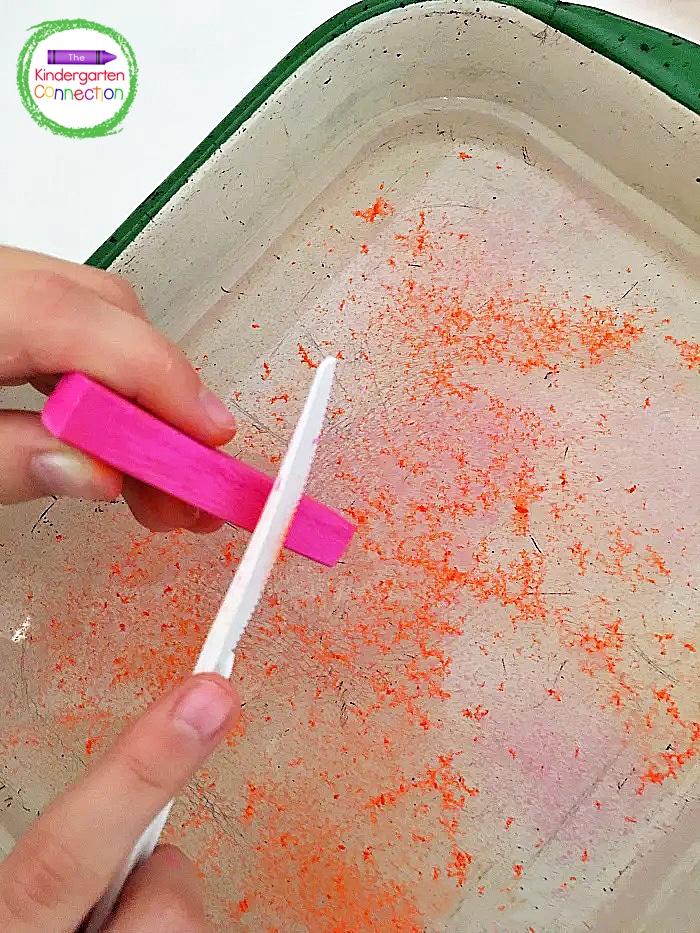 Invite students to use a plastic knife to scrape the edge of a chalk pastel over a dish of water.