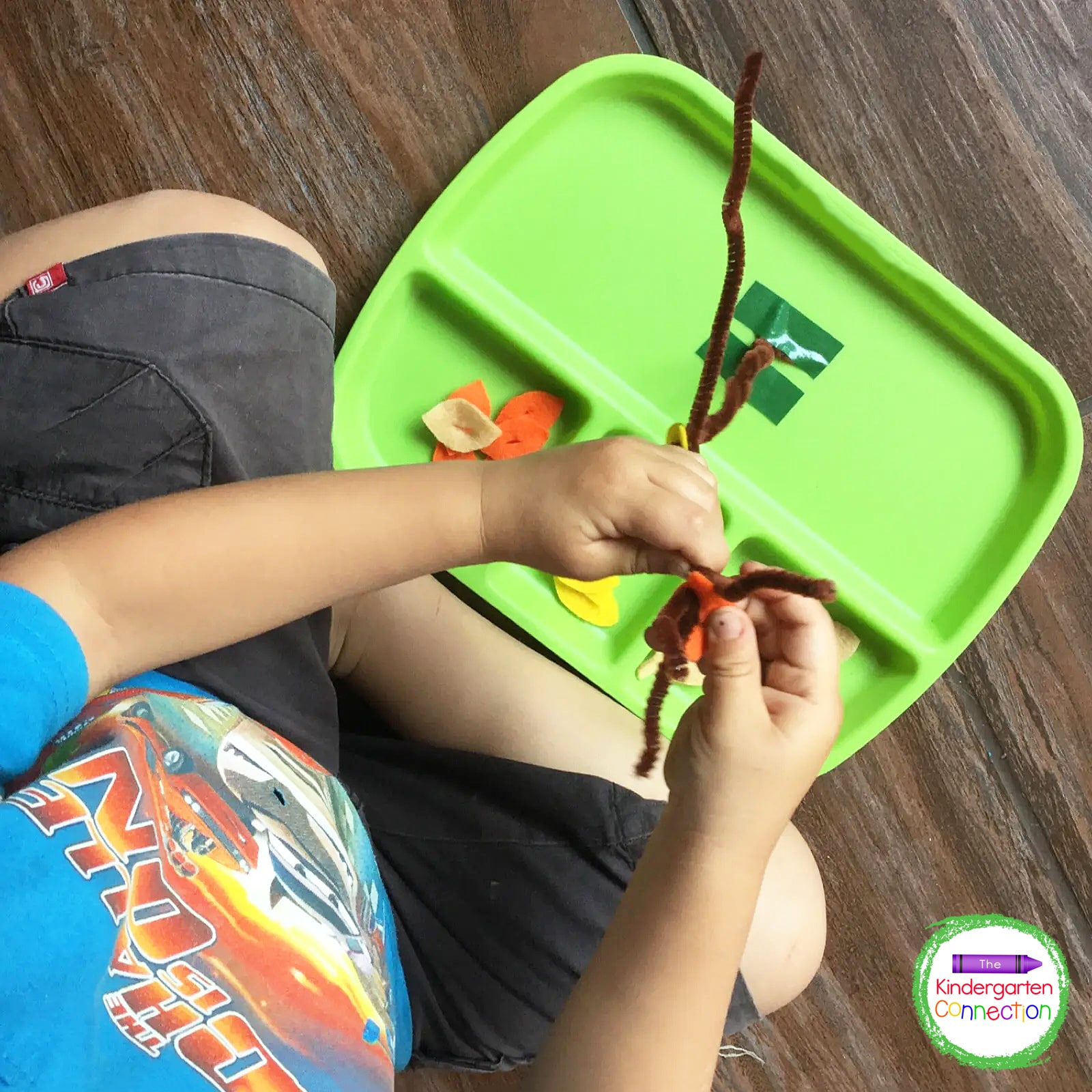 Bend the pipe cleaner into the shape of a tree and attach to a tray securely using tape.