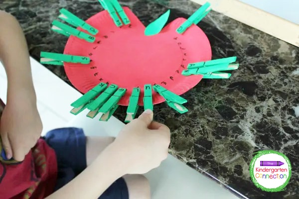 Kids pick a green clothespin and match the uppercase letter to the lowercase letter on the apple plate.