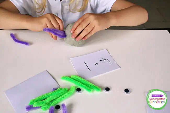 Students pick an equation and use the numbers and pipe cleaners to add legs to their play dough spiders.