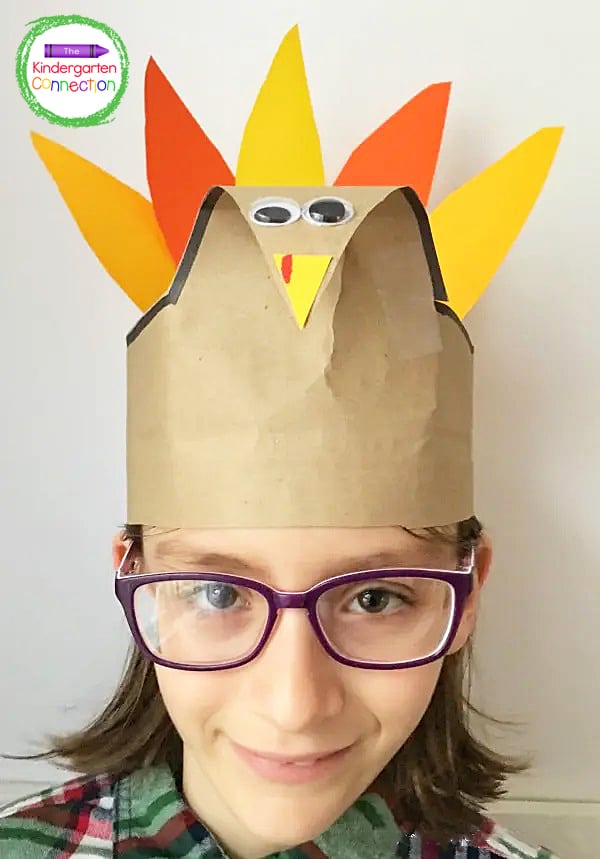 Use tape to secure the paper feathers to the inside of the turkey hat's band.