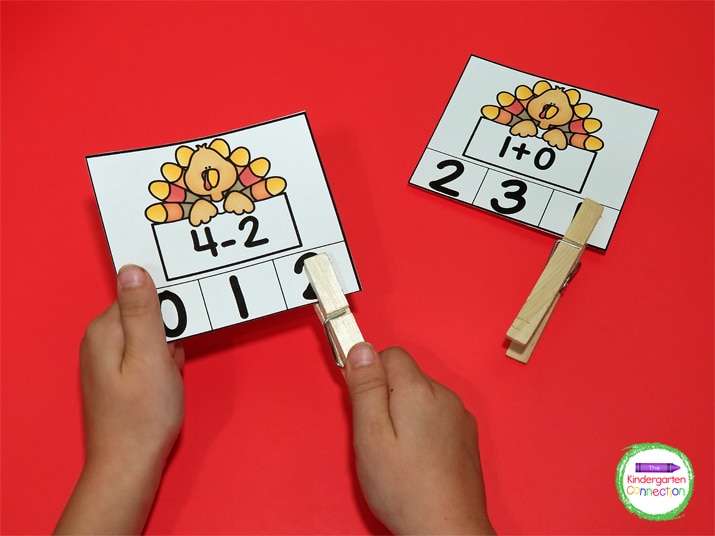 Students solve the addition or subtraction problem and clip the correct number on the card.