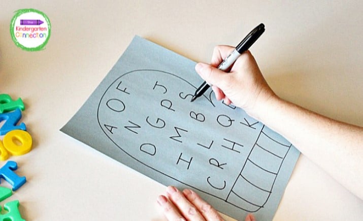 Grab a black marker and quickly sketch a large mitten and letters onto a piece of construction paper.