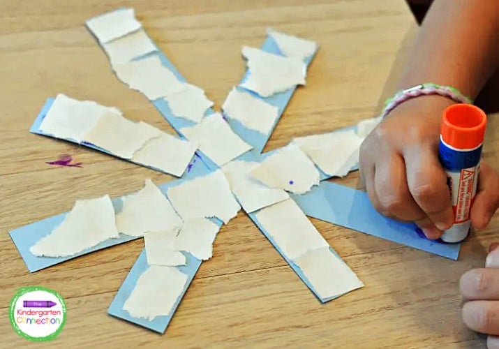 The last step is to glue the white pieces of paper to their blue snowflake base.