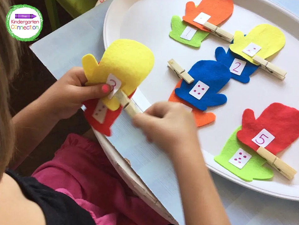 Students count the dots on their mitten, find the mitten with the matching numeral, and clip them together.