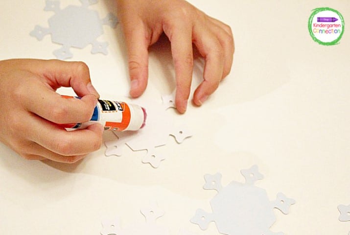Once you've decided on the path that the game players will follow, glue down your snowflake pieces to your game board.