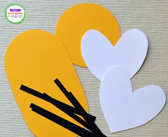 To begin, cut the body and head for your bee from yellow paper. Cut two small heart-shaped wings from white paper.