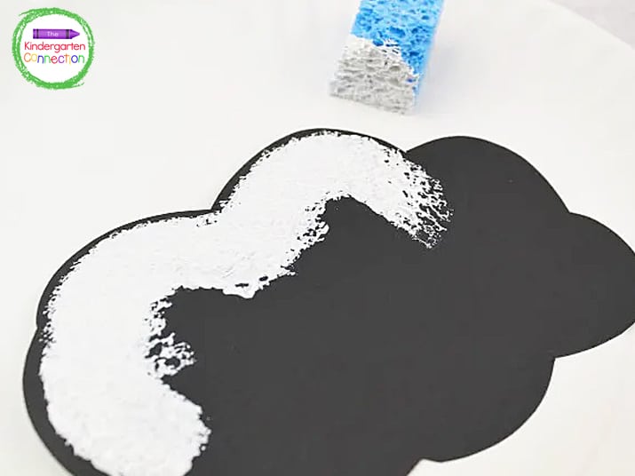 Cut cloud shapes from black cardstock. Use a sponge to dab white paint across the entire cloud, leaving a small black border.