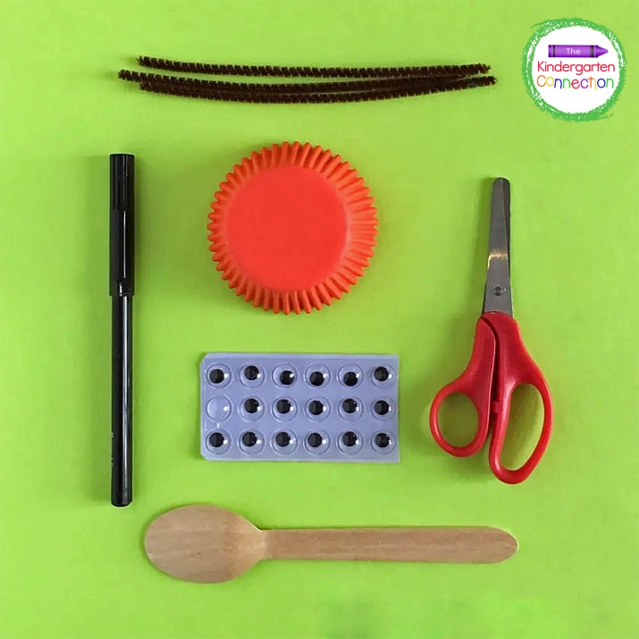 Supplies needed included wooden craft spoons, red cupcake liners, black markers, wiggle eyes, and pipe cleaners.