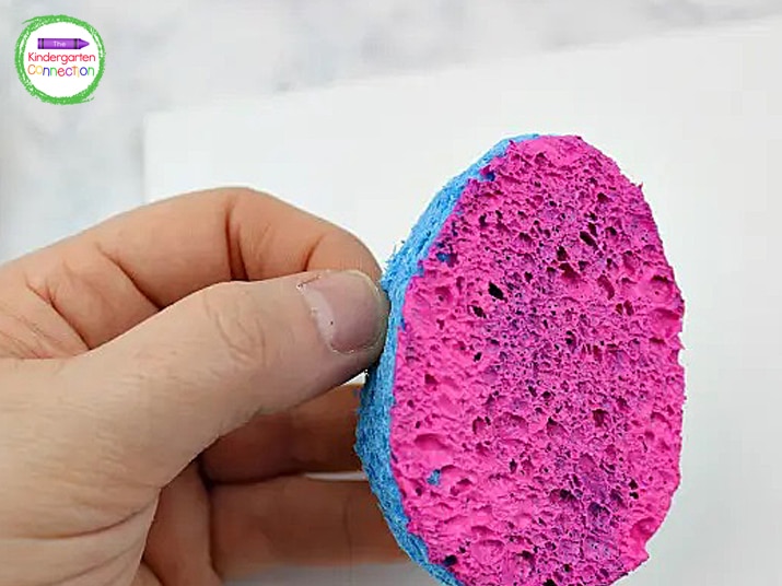 Dip the egg-shaped sponges into paint and press them onto the canvas.