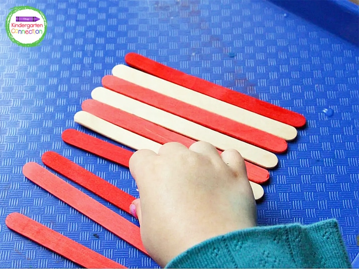 We alternated the red and white popsicle sticks until we had the correct shape for our flag.