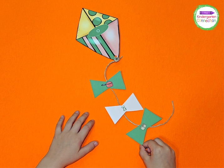 Students will pick a kite tail, say the name of the picture on the card, and add it to the correct kite string.