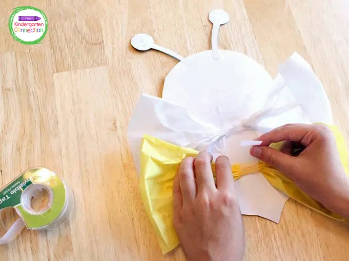 Using a piece of tape, adhere your bumble bee wings to the back of the body.