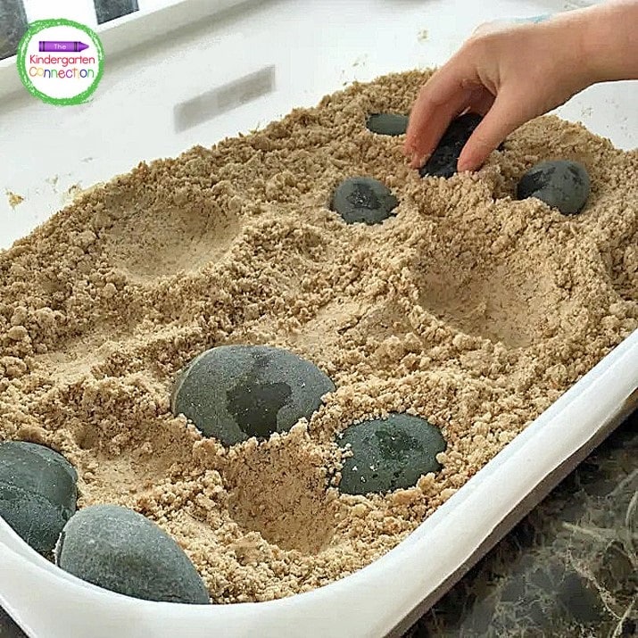 Add some moon sand to a deep tub with an assortment of stones for a fun sand sensory bin activity.