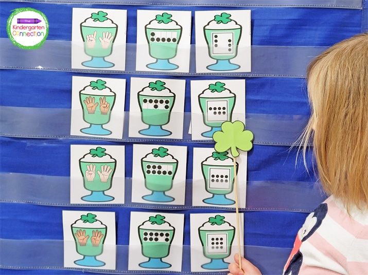 Sudents pick a shake card in the pocket chart that they think a shamrock is hiding behind.