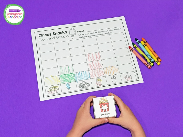 Students roll the printable die and color a box above the circus-themed picture on the graph.