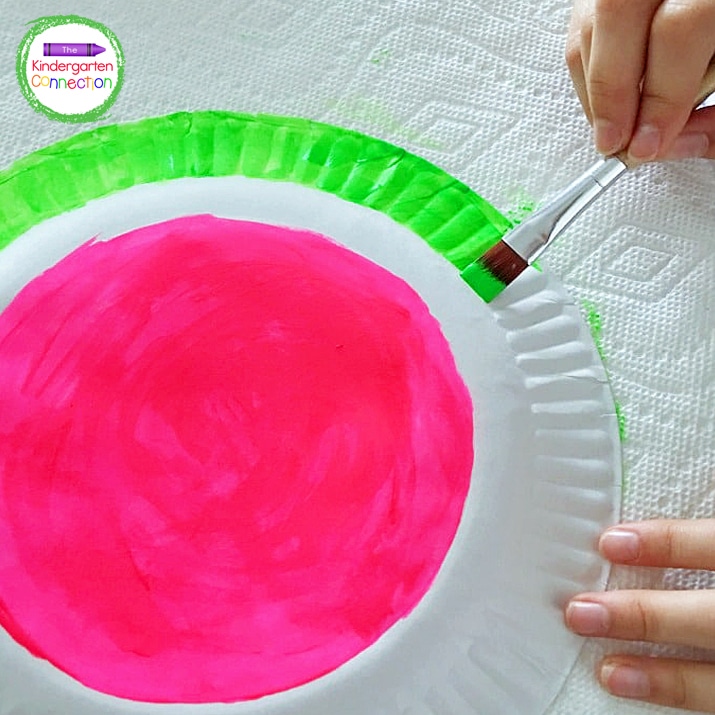Begin by painting the center of the plate pink and the rim of the plate green.
