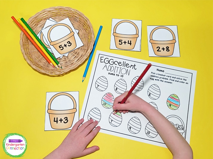 Students pick a basket card, solve the equation, and color the matching sum on the recording sheet.